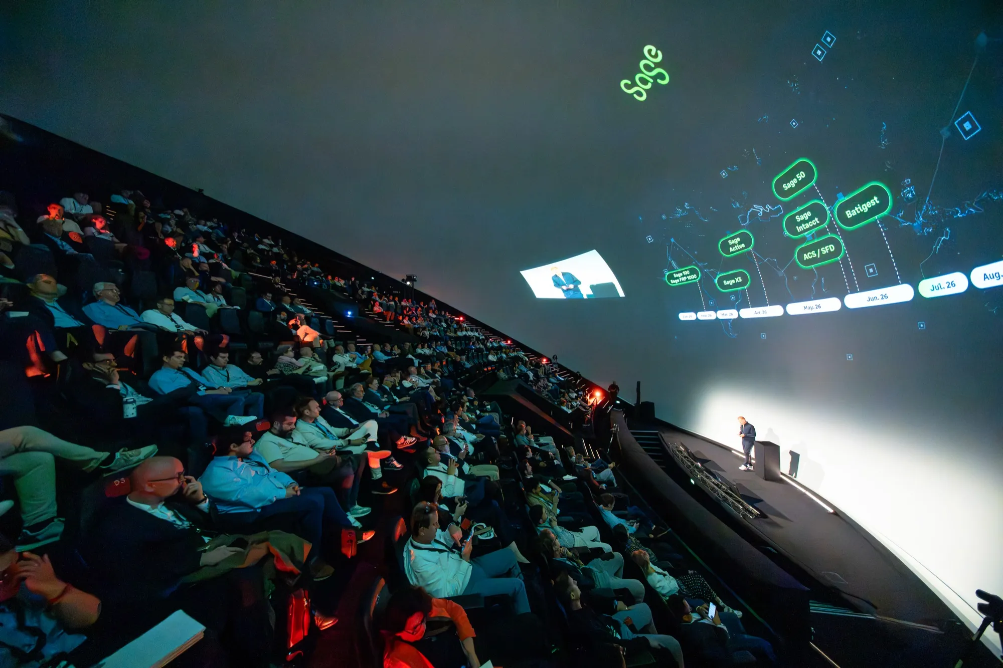 Nicolas Levi on stage in a full auditorium